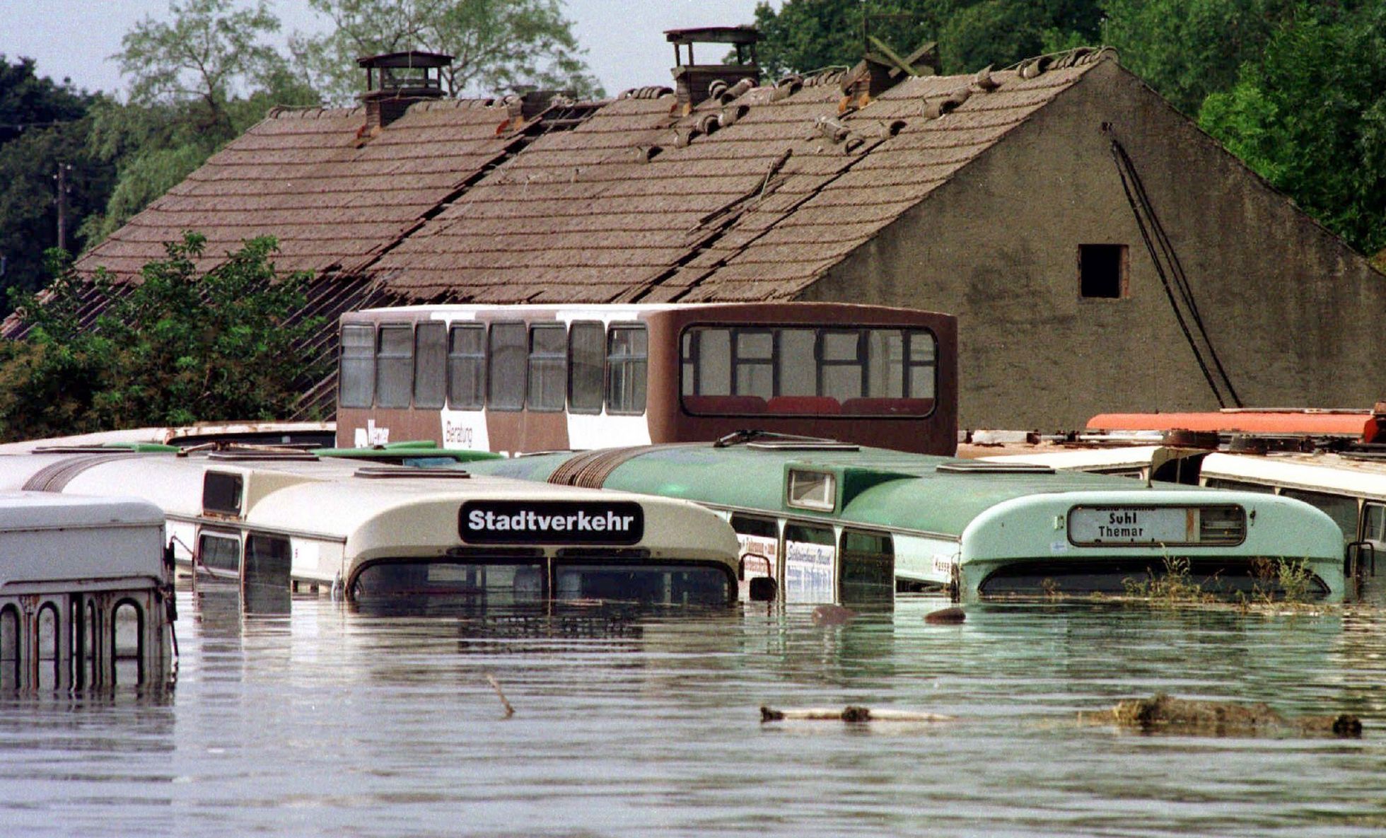 Fast bis zum Dach unter Wasser stehen Busse am 27.7.1997 in der vom Oderhochwasser überfluteten Thälmann-Siedlung nahe dem brandenburgischen Eisenhüttenstadt. Einige Orte in der Ziltendorfer Niederung stehen seit Tagen teilweise bis zu den Hausdächern in den Fluten. Insgesamt mußten in dem Gebiet 436 Menschen evakuiert werden, 1300 Helfer seien im Einsatz. Angesichts auslaufenden Öls aus Tanks und Fahrzeugen schloß ein Chemiker eine Gefährdung der Umwelt nicht aus. Foto: dpa/ Ralf Hirschberger