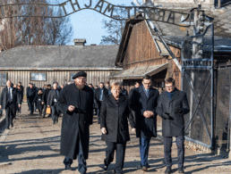 Bundeskanzlerin Angela Merkel besucht das ehemalige deutsche Konzentrationslager Auschwitz und geht zusammen mit dem polnischen Ministerpräsidenten Mateusz Morawiecki (rechts neben Merkel) und dem Direktor der Gedenkstätte und Präsidenten der Stiftung Auschwitz-Birkenau, Piotr Cywinski (links neben Merkel), durch das Eingangstor mit dem Schriftzug "Arbeit macht frei". Ganz rechts geht Andrzej Kacorzyk, Vizedirektor de Museums Auschwitz-Birkenau. Foto: picture alliance/Robert Michael/dpa-Zentralbild/dpa