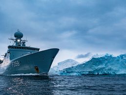 Die Fregatte „HDMS Triton” der Königlich Dänischen Marine passiert einen Eisberg in den Gewässern um Grönland: Auch auf die Seefahrt wirkt sich der Klimawandel in vielen Bereichen aus. Foto: NATO/Flickr