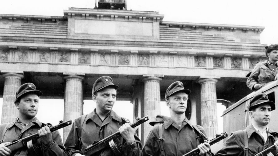 Angehörige der Kampfgruppen der DDR stehen Mitte August 1961 auf der westlichen Seite des Brandenburger Tores in Berlin. Foto: picture alliance / ZB