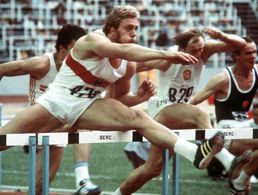 Der deutsche Zehnkämpfer Guido Kratschmer (vorn) nimmt eine Hürde in seinem Lauf bei den Olympischen Sommerspielen am 30. Juli 1976 im Olympiastadion in Montreal. Der Mainzer schafft im Hürdensprint zum Auftakt des zweiten Tages eine Zeit von 14,84 s. Am Ende erreicht er die neue bundesdeutsche Rekordpunktzahl 8.411, womit er sich die Silbermedaille sichert. Foto: picture-alliance / dpa | Roland Witschel