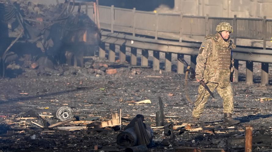 Ein ukrainischer Soldat in Kiew, im Hintergrund das verkohlte Wrack eines Militärfahrzeugs. In der Nacht ist in der ukrainischen Hauptstadt zu schweren Gefechten gekommen. Nach ukrainischen Angaben ist die Lage unter Kontrolle. Foto: picture alliance / ASSOCIATED PRESS / Efrem Lukatsky