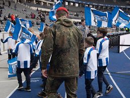 Kein alltäglicher Anblick beim Fußball: Ein Soldat mit Einlaufkindern im Berliner Olympiastadion. Foto: DBwV/Yann Bombeke
