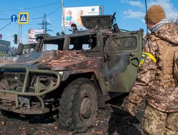 In Charkiw steht ein ukrainischer Soldat vor einem zerstörten russischen Fahrzeug. Seit einer Woche ist Krieg in Europa. Foto: picture alliance / Associated Press / Marienko Andrew