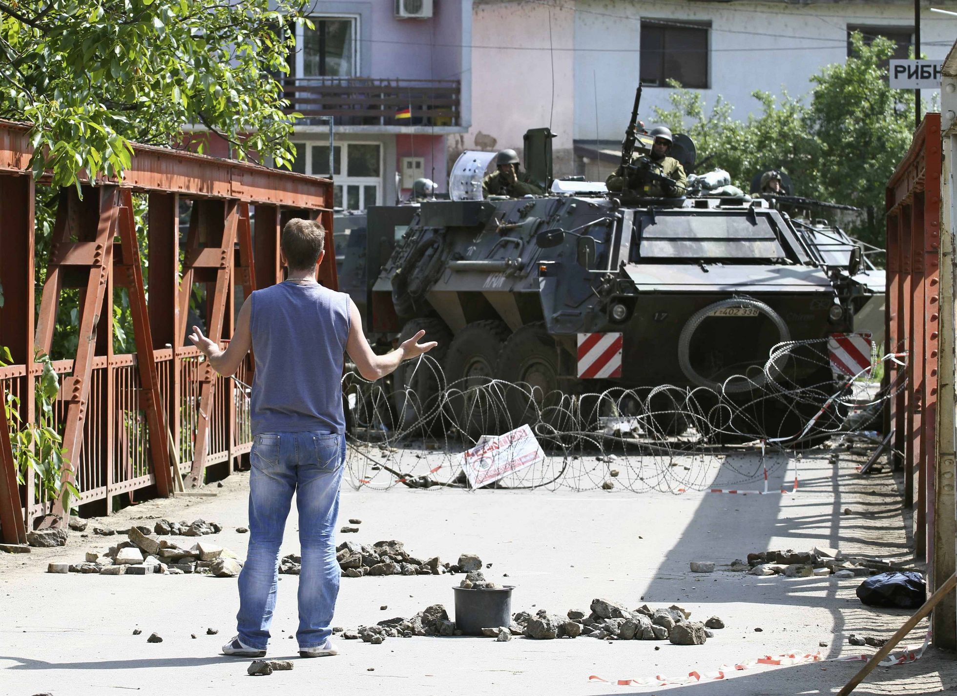 Ein Kosovo-Serbe steht im Juni 2012 an einer Straßenblockade in Zvecan im Norden des Kosovo einem Transportpanzer Fuchs der Bundeswehr gegenüber. Foto: pictue alliance/Reuters/Stringer