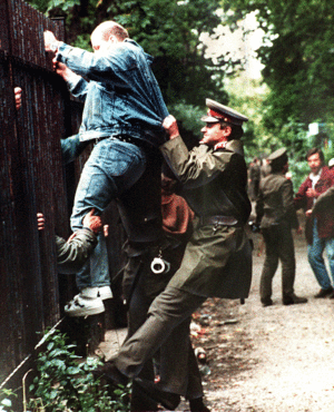 Herbst 1989: Ein tschechoslowakischer Polizist versucht einen DDR-Flüchtling daran zu hindern, auf das Gelände der deutschen Botschaft in Prag zu gelangen. Foto: dpa