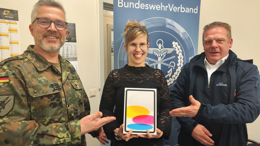 Stabsfeldwebel Sven Wille, Vorsitzender der Truppenkameradschaft Luftwaffe, und Außendienstmitarbeiter Björn Hellmund übereichen Gewinnerin Anne Scholz ein neues iPad. Foto: DBwV