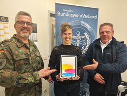 Stabsfeldwebel Sven Wille, Vorsitzender der Truppenkameradschaft Luftwaffe, und Außendienstmitarbeiter Björn Hellmund übereichen Gewinnerin Anne Scholz ein neues iPad. Foto: DBwV