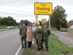 Oberstleutnant Dr. Gößlbauer (v.l.n.r.), Bürgermeisterin Riedl, Oberstleutnant Zimmermann und Stabsfeldwebel Schleicher vor der Gelben Schleife am Rodinger Ortsschild von der B85 kommend. Foto: Marco Schultz