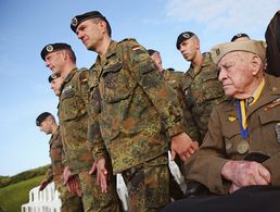 Deutsche Soldaten neben einem Veteran des Zweiten Weltkriegs bei den Gedenkfeiern zum 70. Jahrestag der Invasion in der Normandie (D-Day). Unterschiedliche Kulturen prägen den Umgang mit Veteranen. Foto: getty images