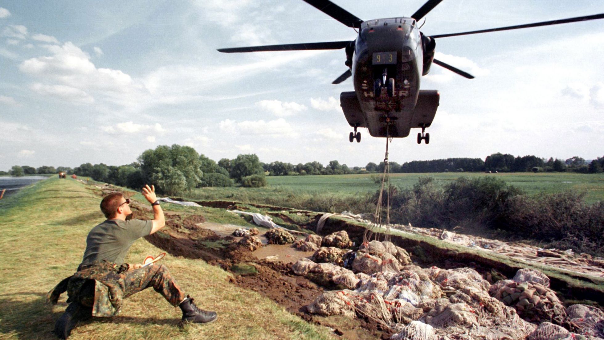 Ein CH-53-Hubschrauber der Heeresflieger lädt am 30.7.1997 Sandsäcke in das abgesackte Teilstück am Oderdeich bei Hohenwutzen. Foto:dpa/Kay Nietfeld