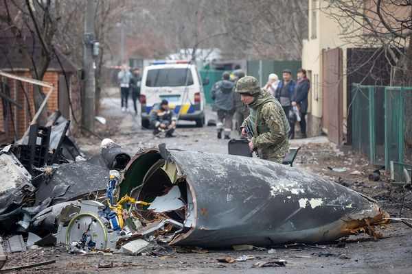 Ein ukrainischer Soldat beugt sich über die Wrackteile eines in Kiew abgestürzten Kampfjets. Es ist unklar, von welcher Seite das Flugzeug stammt und was es zum Absturz brachte. Foto: picture alliance / ASSOCIATED PRESS | Vadim Zamirovsky