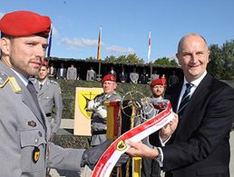 Ministerpräsident Dietmar Woidke (rechts) heftete das Ehrenband an die Bataillonsfahne. Foto: Claudia Marsal, NORDKURIER MEDIENGRUPPE