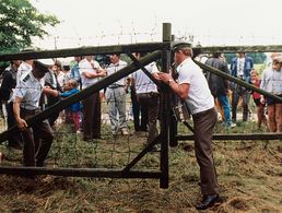 Am 19. August 1989: Österreichische Grenzbeamte öffnen ein Grenztor. Etwa 500 DDR-Bürger nutzten ein paneuropäisches Picknick an der ungarisch-österreichischen Grenze, bei dem ein Grenztor symbolisch geöffnet wurde, zur Flucht in den Westen. Foto: dpa/Votava