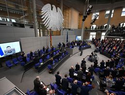 Der ukrainische Präsident Wolodymyr Selenskyj spricht auf einer Videoleinwand im Bundestag und bekommt Applaus von den Abgeordneten. Foto: dpa