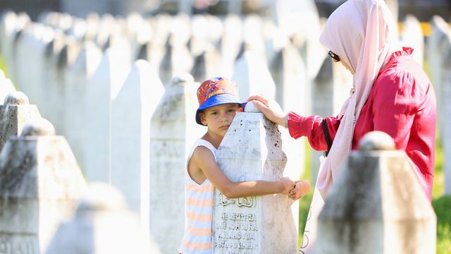 Gedenken zum 29. Jahrestag des Massakers von Srebrenica: Ein bosnischer Junge mit seiner Mutter an einem Grabstein in der Gedenkstätte in Potocari unweit von Srebrenica. Foto: picture alliance/REUTERS/Amel Emric