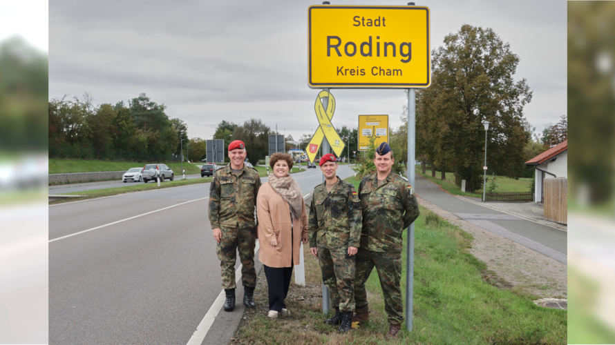 Oberstleutnant Dr. Tobias Gößlbauer (v.l.n.r.), Bürgermeisterin Alexandra Riedl, Oberstleutnant Thomas Zimmermann und Stabsfeldwebel Christian Schleicher bei der Übergabe der Gelben Schleife am Rodinger Ortsschild an der B85. Foto: Marco Schultz