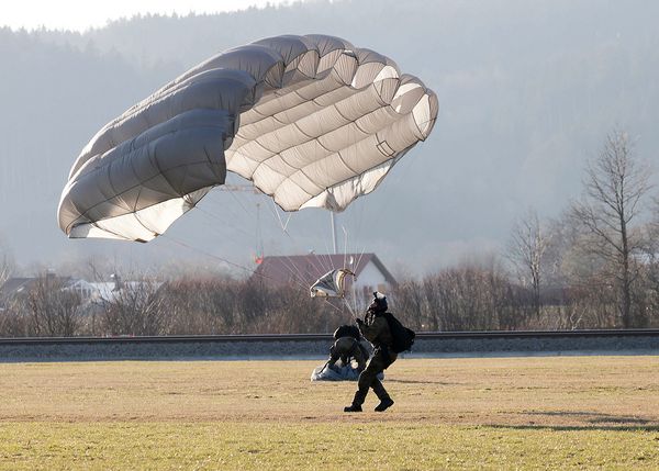 Ein Soldat bringt nach der Landung seinen Fallschirm kontrolliert zu Boden. Foto: Gebirgsjägerbrigade 23/Tobias Skinner