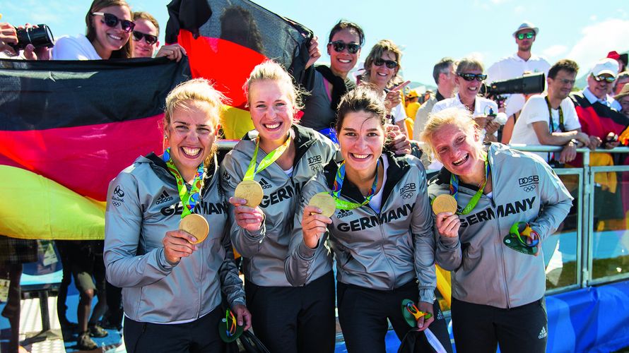 Das deutsche Team um Sportsoldatin Stabsunteroffizier Julia Lier (2.v.l.) jubelt zusammen mit deutschen Fans über Gold in der Ruderregatta bei den Olympischen Spielen 2016. Foto: Bundeswehr/Jane Schmidt