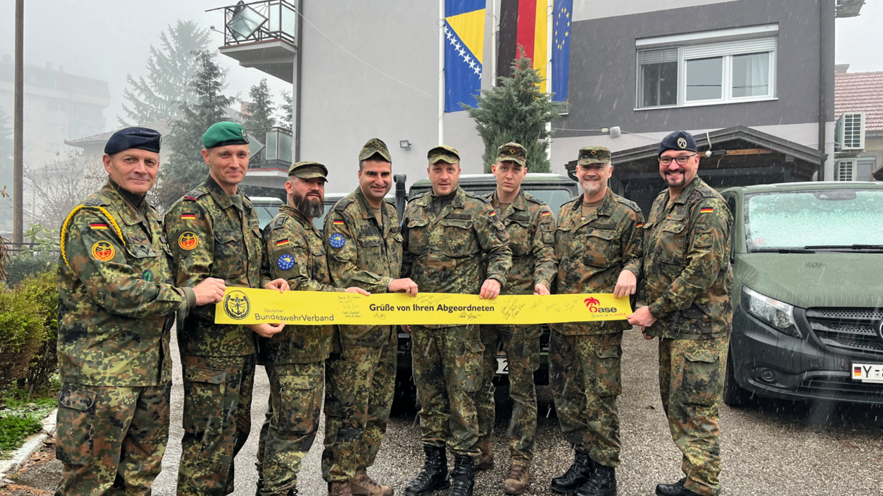 Vor dem LOT-Haus in Vlasenica: Ein Gelbes Band vom BundeswehrVerband für die Truppe: Bei der Übergabe Frank Schmitt, Beauftragter Auslandseinsätze, Oberstleutnant i.G. Marcel Bohnert und Major Ronald Hartwig, Chef des Liaison Operation Teams in Vlasenica. Foto: DBwV/Frank Jungbluth